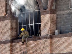 Miembros del cuerpo de bomberos intentan rescatar a las víctimas del incendio. NTX  /