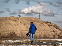 Tang Liang se encamina a medir la contaminación del incinerador de basura cercano a su departamento ayer, en Beijing, China. AP  /