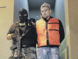 Omar “El Gato” Ortiz es escoltado por un policía. REUTERS  /