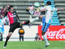 El zaguero argentino de Atlas, Facundo Erpen, disputa el esférico con el jugador poblano Lucas Silva. NTX  /