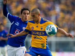 Omar Bravo (i) lucha por balón contra Torres Nilo durante encuentro Tigres - Cruz Azul, donde el marcador benefició a los primeros. AFP  /