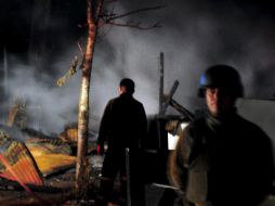 Agentes vigilan los restos de las instalaciones quemadas en lazona del conflicto mapuche. EFE  /