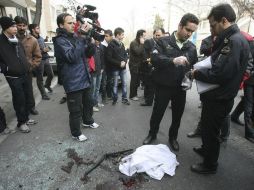 La policía recaba pruebas en el lugar donde se produjo el atentado que ha causado la muerte del científico Mustafá Ahmadi Roshan.EFE  /