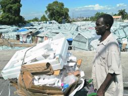 Un hombre recolecta basura frente a un campamento de desplazados, donde aún permanecen más de 500 mil haitianos. AFP  /