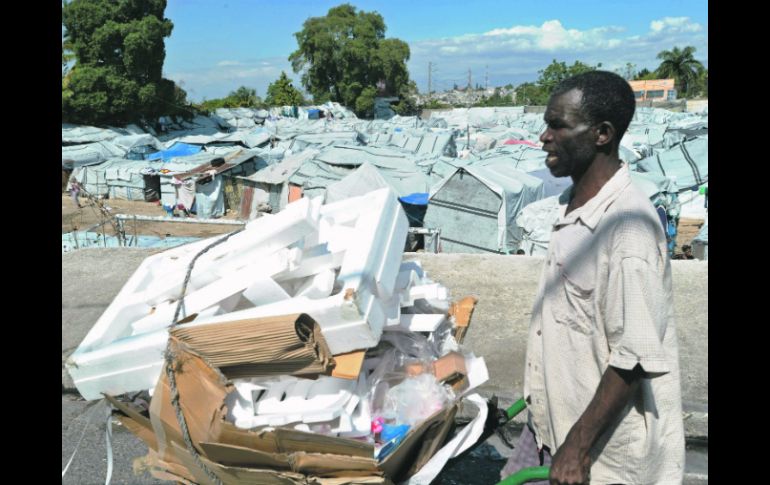 Un hombre recolecta basura frente a un campamento de desplazados, donde aún permanecen más de 500 mil haitianos. AFP  /
