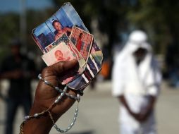 Ginnette Filemón sostiene en su mano fotos de sus tres hijas, un nieto y una tía, muertos durante el terremoto. EFE  /