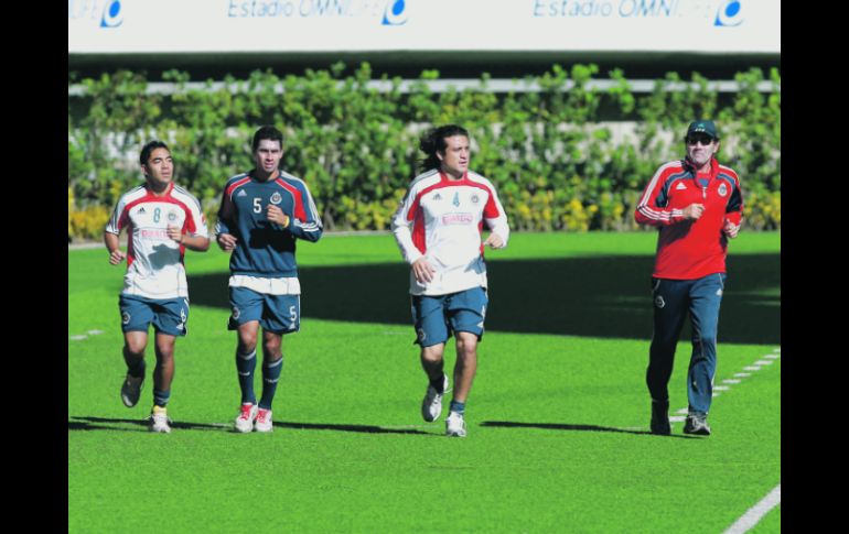 El técnico Fernando Quirarte (der.) trota en la cancha del Estadio Omnilife junto a Héctor Reynoso, Patricio Araujo y Marco Fabián.  /