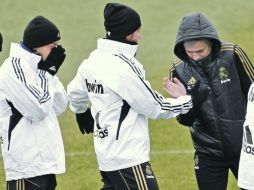 El técnico José Mourinho (d) da la bienvenida a sus pupilos, al ''helado''entrenamiento de ayer en la capital española. EFE  /