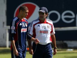 Jorge Enríquez y Fernando Quirarte platican durante la práctica de Chivas. MEXSPORT  /