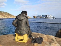 Una mujer observa el crucero Costa Concordia, semihundido en aguas de la isla italiana de Giglio. EFE  /