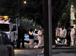 Peritos forenses trabajan en el sitio donde ocho personas fueron asesinadas a tiros.  EFE  /