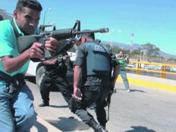 La foto muestra a los agentes ministeriales cuando disparan contra los normalistas el 12 de diciembre en la Autopista del Sol.  /