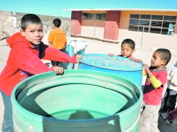 Niños observan la poca agua que contienen los tambos en Durango; al menos cuatro mil bovinos han muerto a causa de la falta del líquido  /