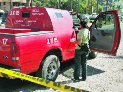 Agentes de la Procuraduría realizan los peritajes en el vehículo de valores, frente a la plaza comercial Villas Vallarta.  /