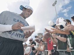 El mariscal novato de las Panteras de Carolina, Cam Newton, firma autógrafos a los aficionados. AP  /
