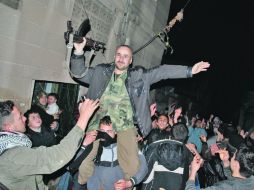Manifestantes opositores piden el alto el fuego y la caída de Bashar al Assad, en Rastán. AP  /