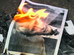 Sirios queman fotos del primer ministro ruso Vladimir Putin por apoyar el régimen de su presidente, Bashar al Assad. EFE  /