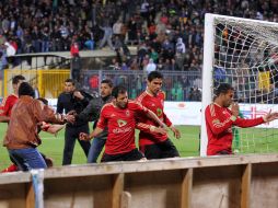 Los jugadores del Al-Haly corren para ponerse a salvo luego de los disturbios en Port Said. AP  /