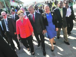 La mandataria brasileña, Dilma Rousseff (i), pasea por las calles de Puerto Príncipe con su homólogo haitiano Michel Martelly (c). AFP  /