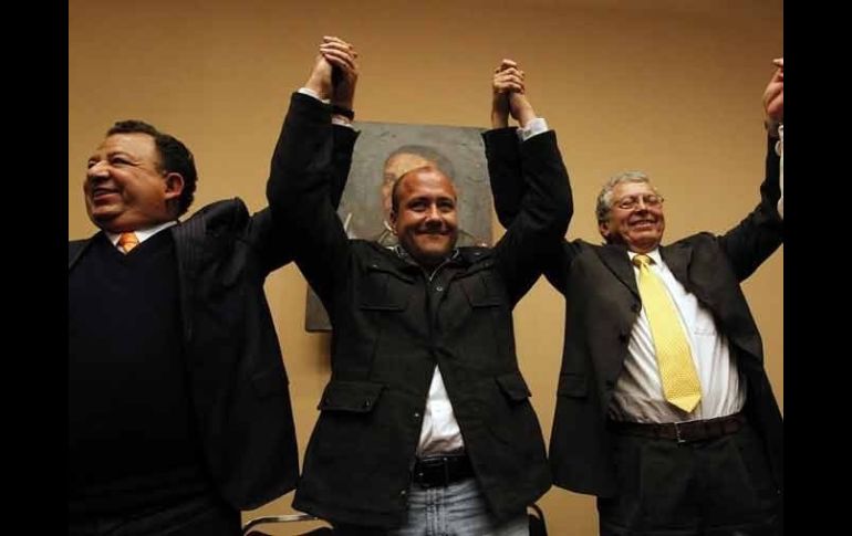 Enrique Alfaro celebra su triunfo escoltado por Luis Walton (izq.) y Manuel Camacho Solís (der.).  /