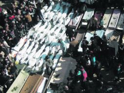 Los habitantes de Homs, en el Centro de Siria, comienzan a enterrar a sus muertos, cuya cifra asciende a 237. AFP  /