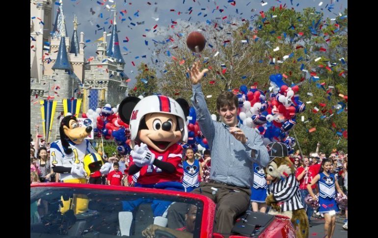 El quarterback de Gigantes, Eli Manning, saluda hoy en un desfile con personajes de Disney por el triunfo en el Super Bowl. EFE  /