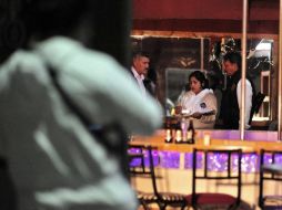 Agentes forenses inspeccionan uno de los comercios que fueron atacados. EFE  /