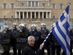 Un manifestante sostiene una bandera de Grecia frente al Parlamento griego. EFE  /