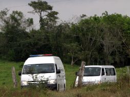 Vehículos del servicio forense acuden al sitio en Acayucan donde se hallaron las fosas. AFP  /