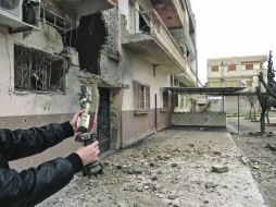 Una persona sosotiene los restos de un proyectil lanzado en el Distrito de Homs. REUTERS  /