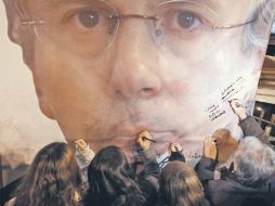 Manifestantes firman un cartel del juez español como muestra de apoyo, luego de darse a conocer la sentencia. EFE  /