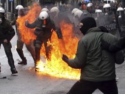 Manifestantes y policías antidisturbios se enfrentan en Atenas, el pueblo griego está descontento por los ajustes. EFE  /