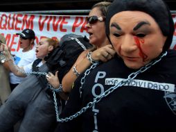 Mujeres protestan encadenadas a muñecos hoy durante una asamblea en el centro de Río de Janeiro. EFE  /