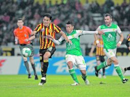 El atacante universitario,Édgar González, disputa el control del esférico con el jugador de León, Luis Antonio Delgado.  /