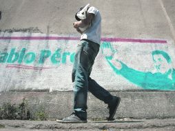 Un hombre camina a un costado de la publicidad del precandidato Pablo Pérez, quien luchará hoy por la candidatura presidencial. EFE  /