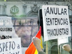 Personas sostienen carteles de apoyo a Baltazar Garzón en una protesta frente al Tribunal Supremo. AP  /