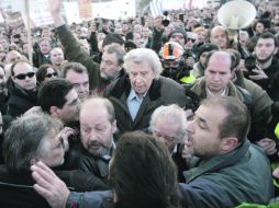 El cantante Mikis Theodorakis (c), uno de los convocantes de la protesta, intenta subir a las escaleras del Parlamento griego. AFP  /
