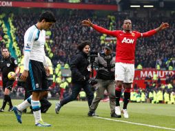 Patrice Evra (d) celebró el triunfo del Manchester frente a Luis Suárez (i). AP  /