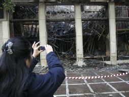 Atenienses observan los daños causados en la ciudad tras los altercados de anoche. EFE  /