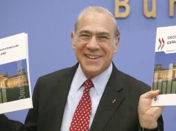El secretario general de la OCDE, José Ángel Gurría, muestra una copia del informe económico durante un acto en Berlín. EFE  /