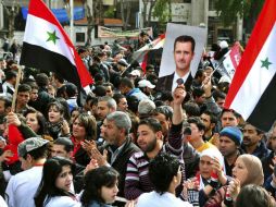 Sirios ondeando banderas de Rusia y Siria durante una manifestación en apoyo al gobierno de Bachar al Asad. EFE  /