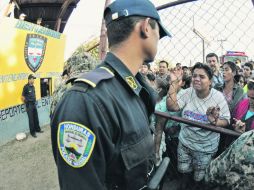 Familiares de los presos de la Granja Penal esperan mortificados tras las rejas por noticias de sus seres queridos. EFE  /