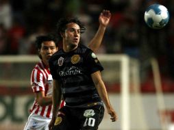 Marco Argüelles, de Leones Negros, observa un balón ante la marca de un zaguero de Rayos del Necaxa. MEXSPORT  /