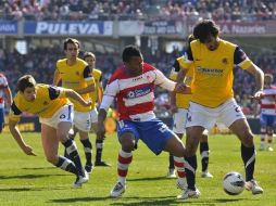 El delantero nigeriano del Granada Ikechukwu Uche intenta robar el balón entre los miembros de la Real Sociedad. EFE  /