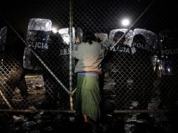 Una mujer empuja hoy una reja del penal de Apocada, la cual es resguardada por policías. REUTERS  /
