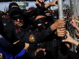 Reconocen que los reos evadidos son de alta peligrosidad. En la imagen, policías intentan contener a los familiares de los reos. EFE  /