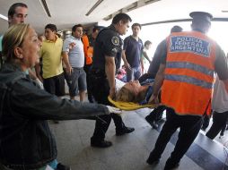 Los rescatistas trasladan a una de las heridas. AP  /