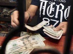 El precio mínimo a la compra de la moneda estadounidense se dio en 12.30 pesos en Tijuana. ARCHIVO  /