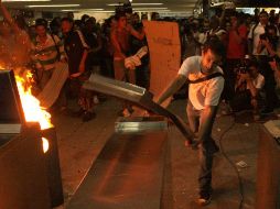Una multitud causó destrozos en protestas, luego de hoy se encontró otro cadáver en el tren que chocó el miércoles en Buenos Aires. AP  /