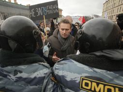 El líder opositor, Alexey Navalny, trata de hablar con los policías que obstruyen la ruta de la manifestación. AP  /